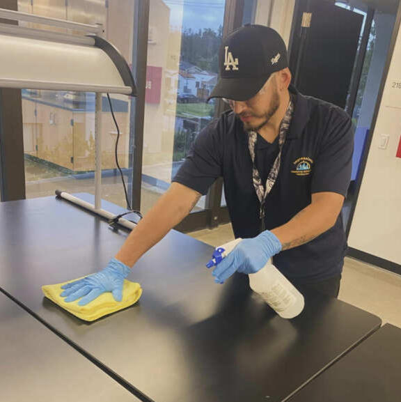 Impressions Commercial Maintenance Professional Cleaning Staff cleaning stainless steel counter Impressions Commercial Maintenance Professional Cleaning Staff cleaning stainless steel counter